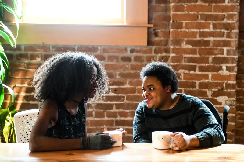 Two women talking over coffee at a cafe table